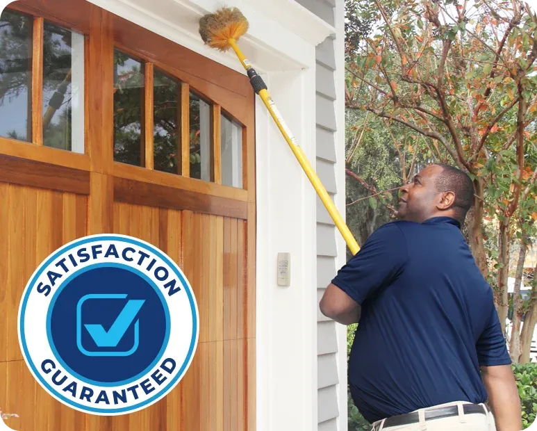 technician sweeping exterior of house